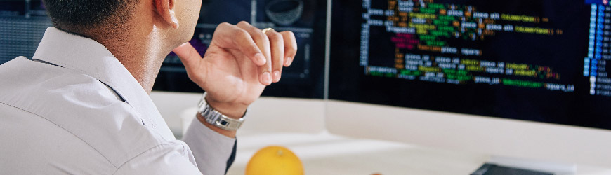 Developer coding and watching monitors